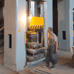 Press machine in operation, worker overseeing the process